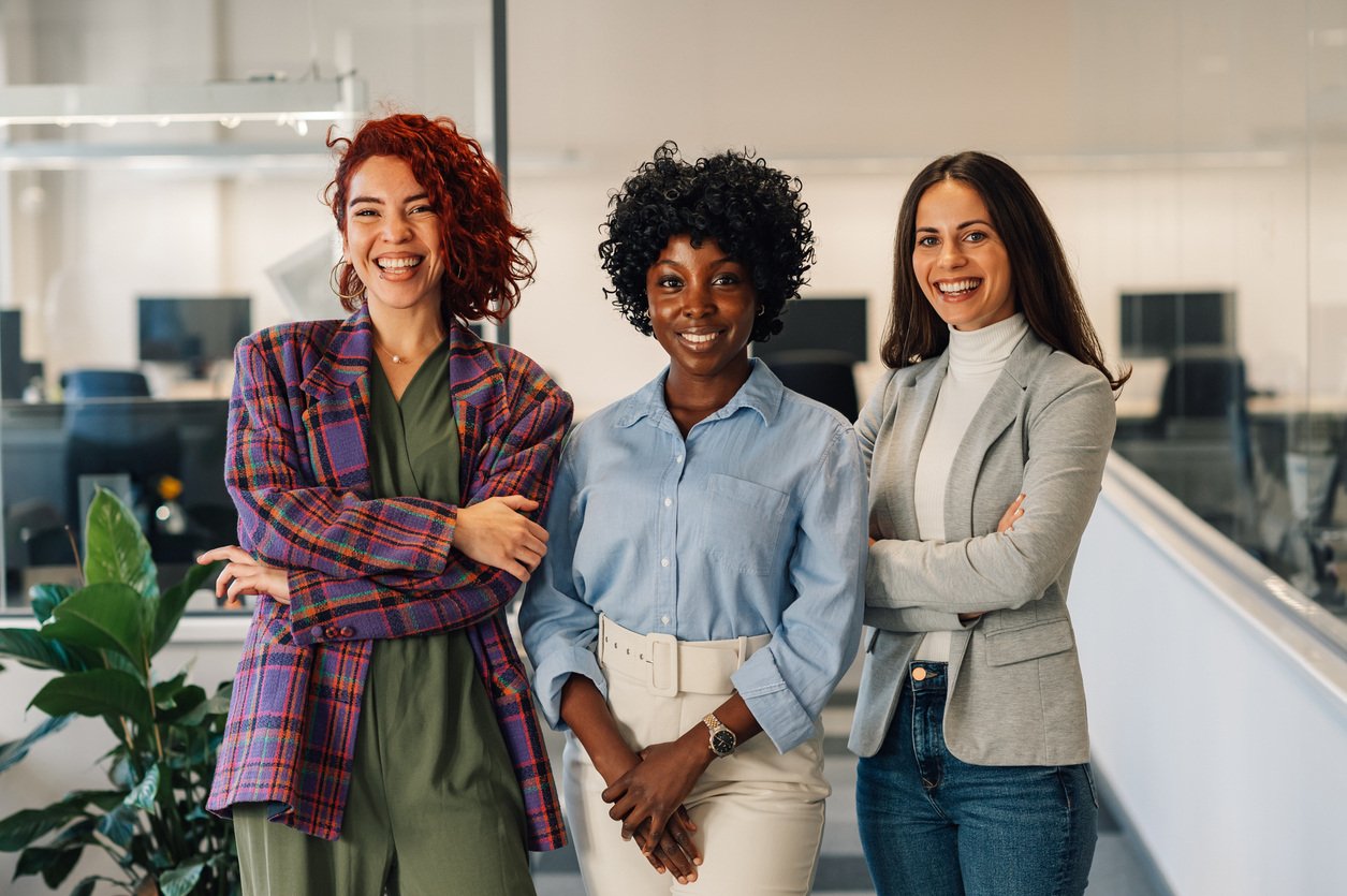 Three women posing in an office