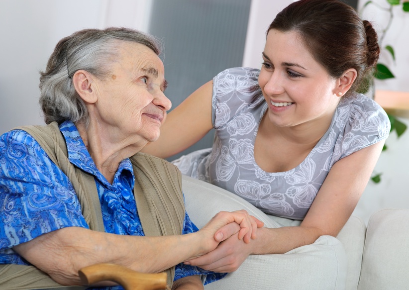 Health care aide helping elderly woman