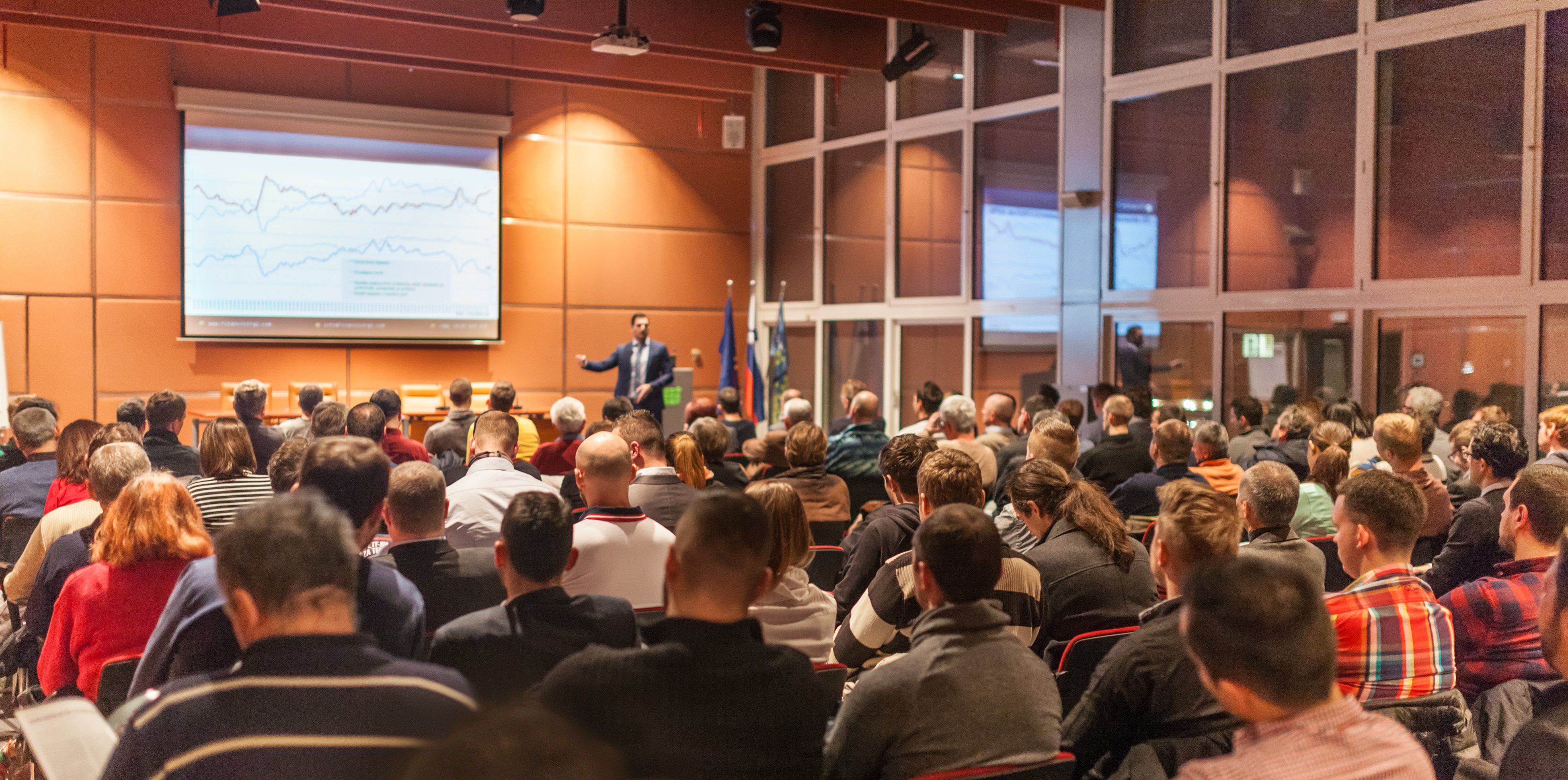 Speaker giving a talk to a crowd in a large conference hall