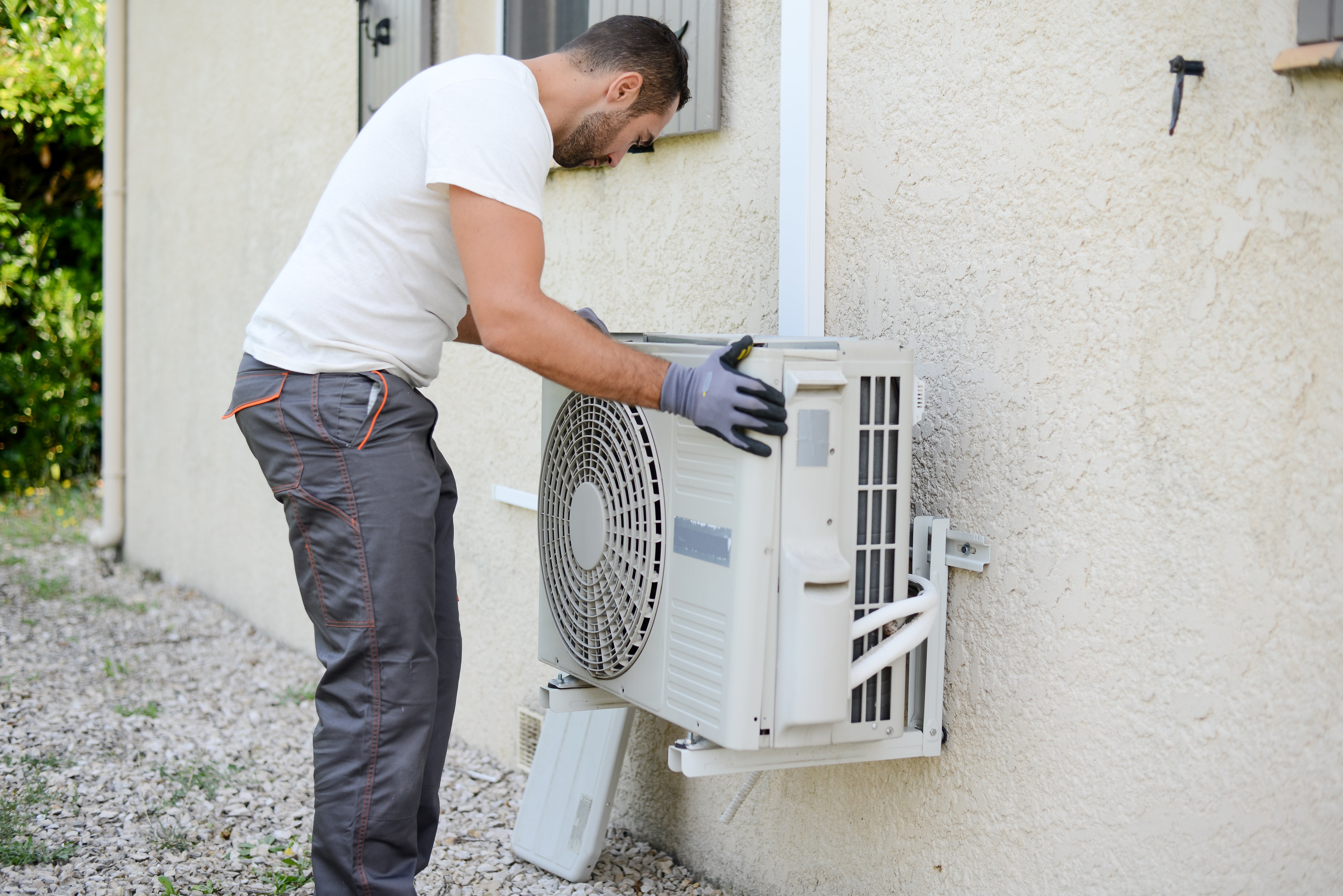 HVAC technician installing air conditioning unit