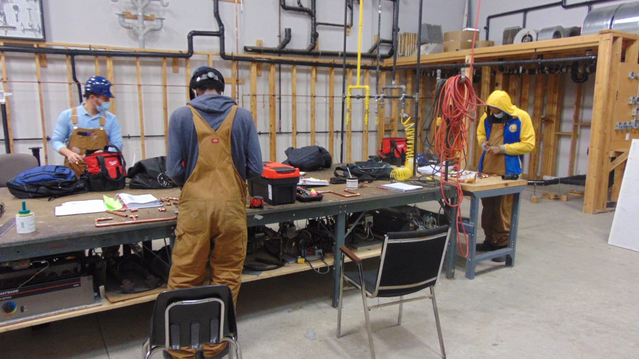 Plumbing students in the Herzing workshop