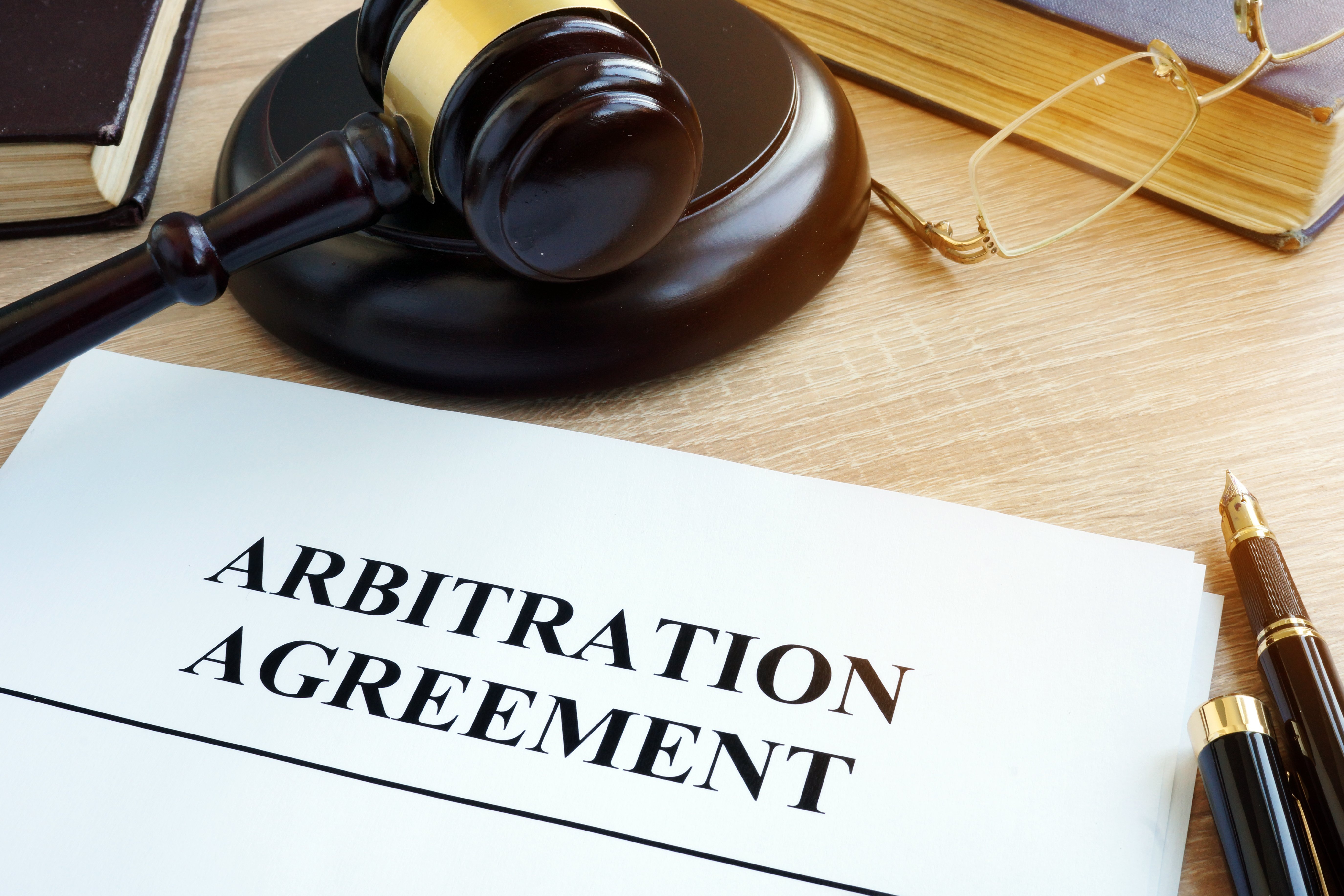 Arbitration agreement lying on desk next to gavel