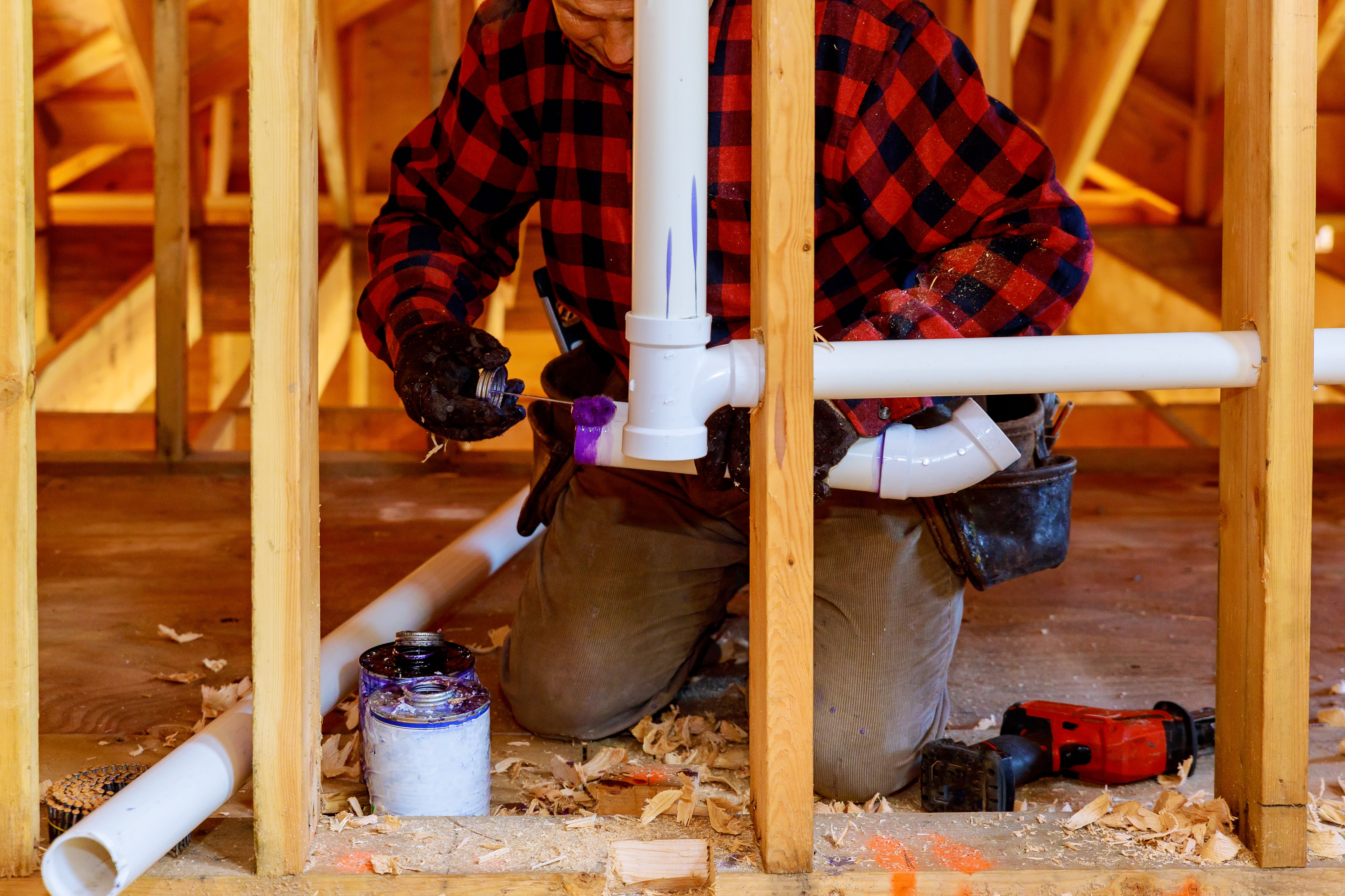 Plumber installing pipes in new home