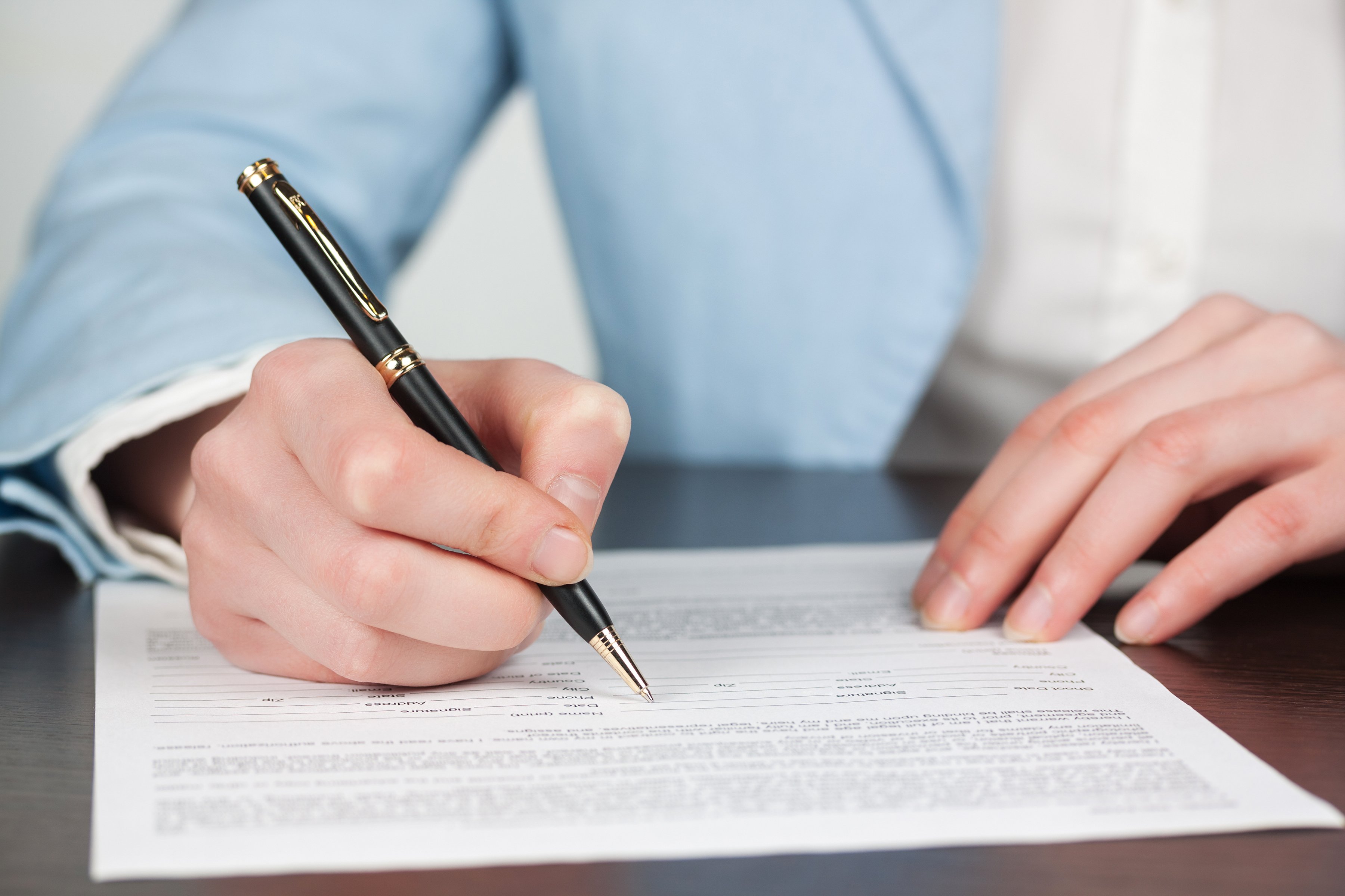 Closeup of woman signing contract