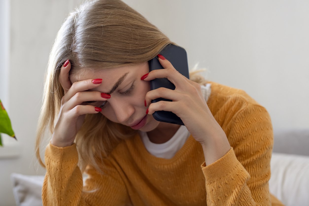 Woman looking stressed while talking on her phone