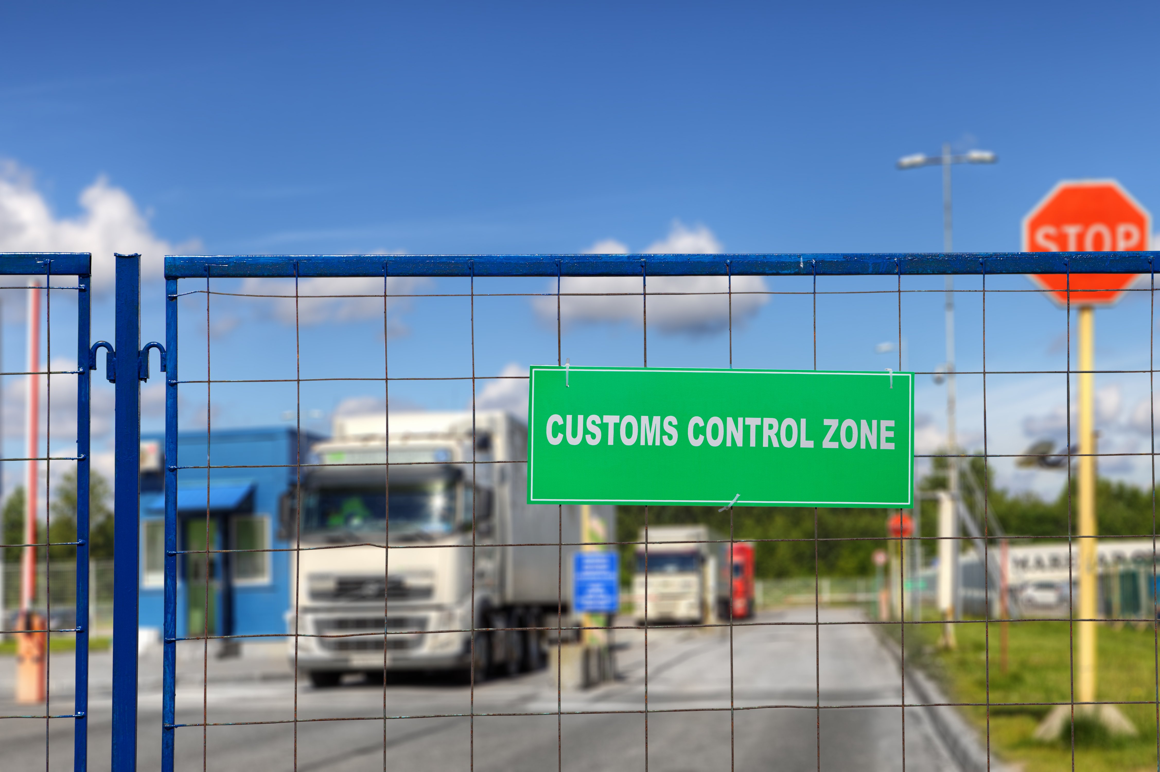 Trucks lined up behind fence at customs control zone