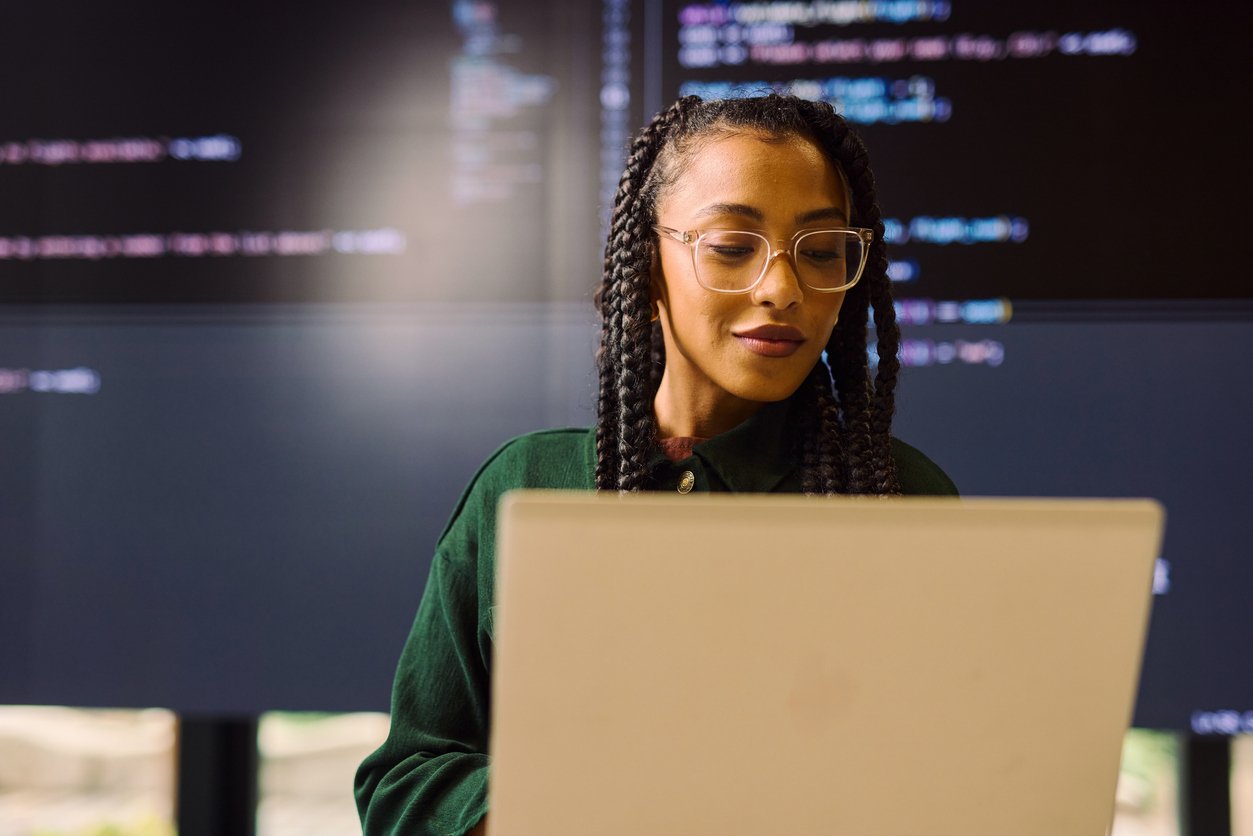 Young cybersecurity specialist analyzing code on laptop