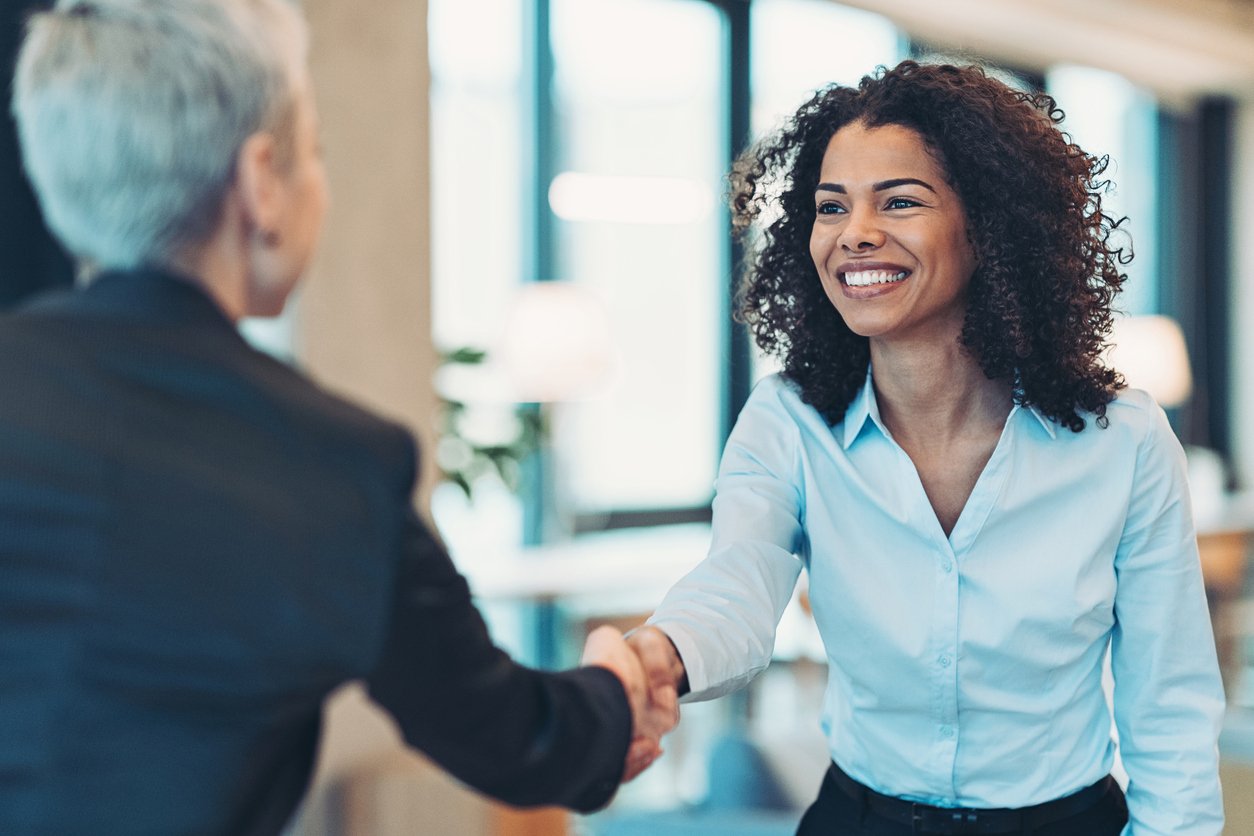 Smiling businesswoman shaking the hand of a hiring manager