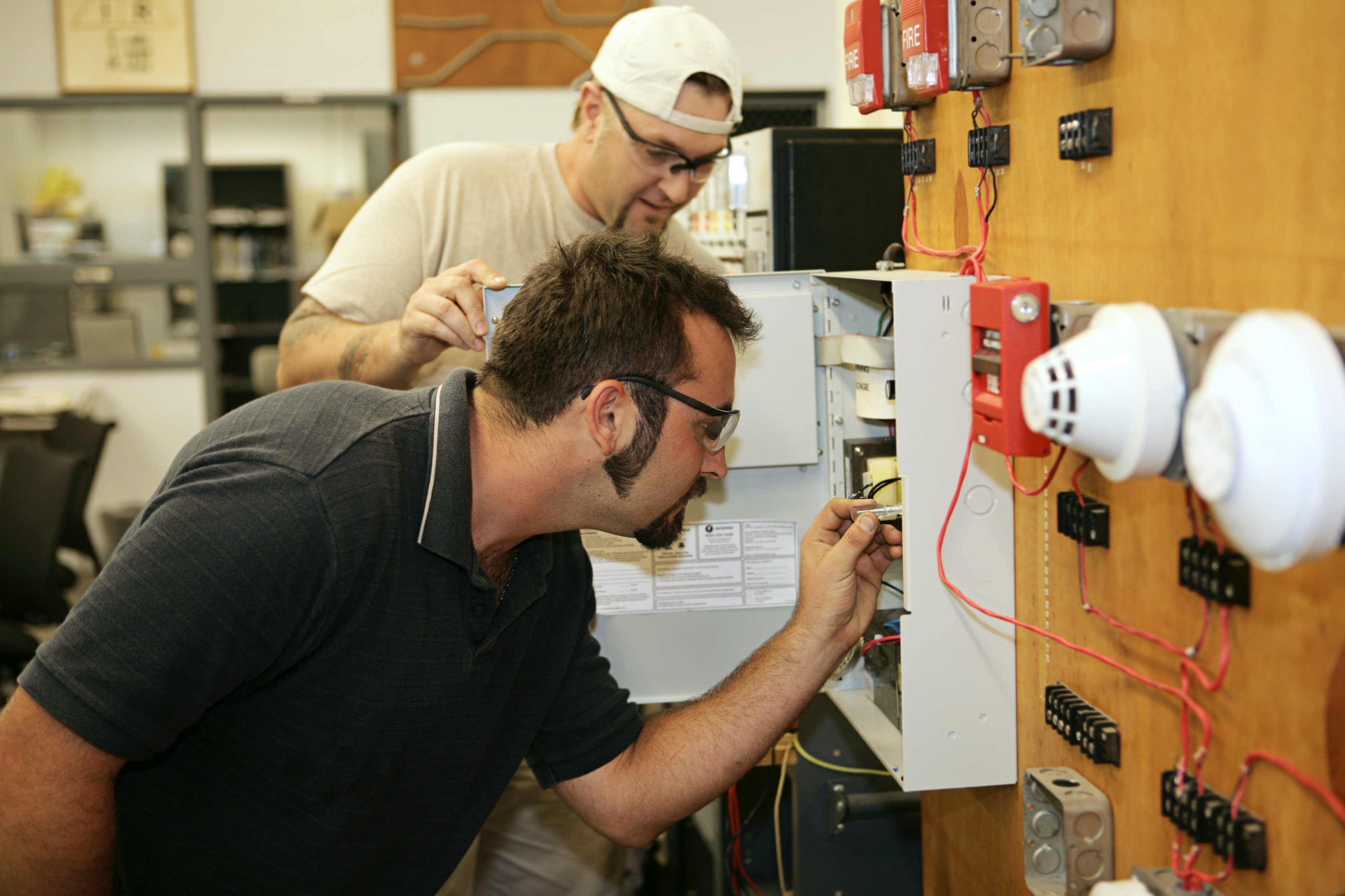Trade school student learning how to wire a fire alarm system