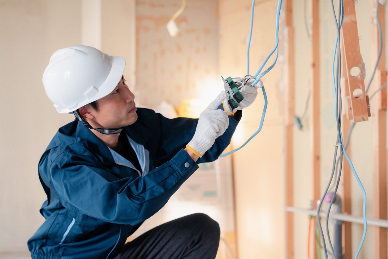 An electrician working on wiring at a construction site