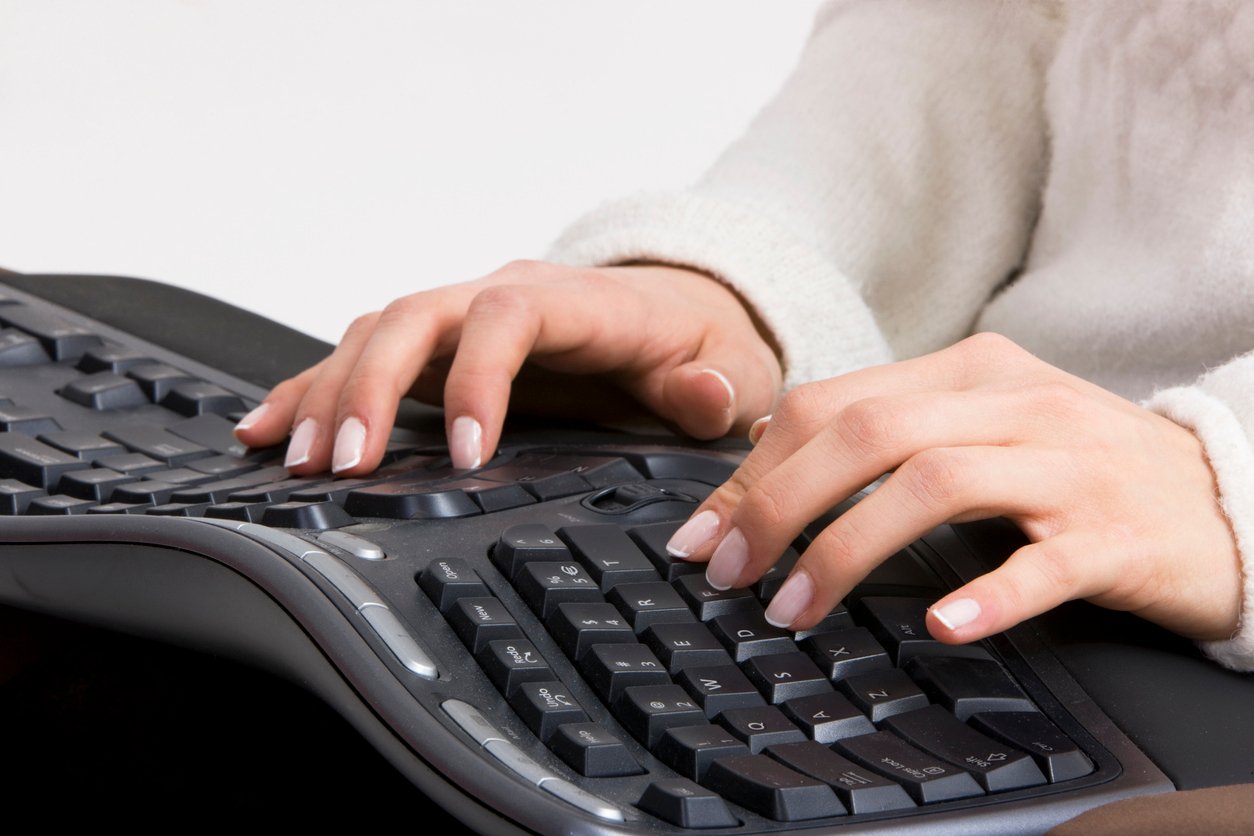 Une femme utilise un clavier ergonomique