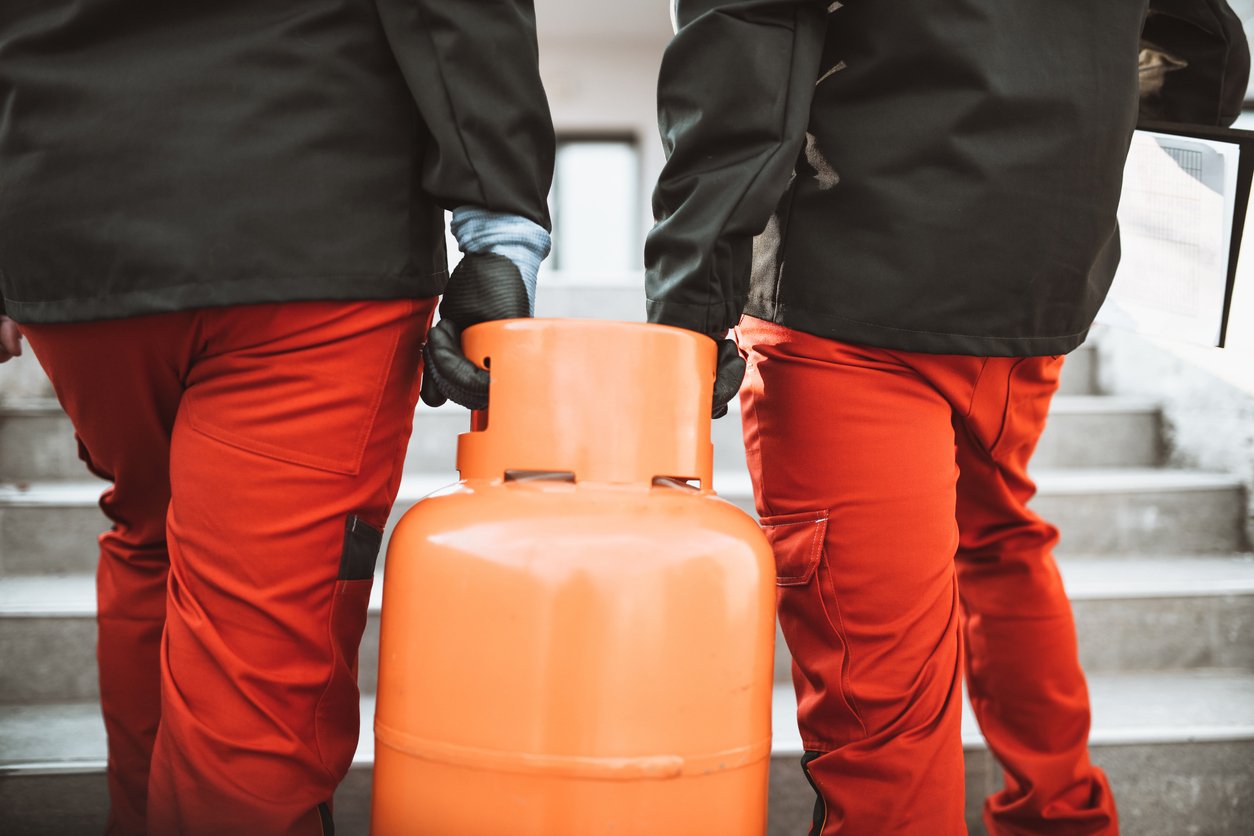 Technicians carrying a gas cylinder