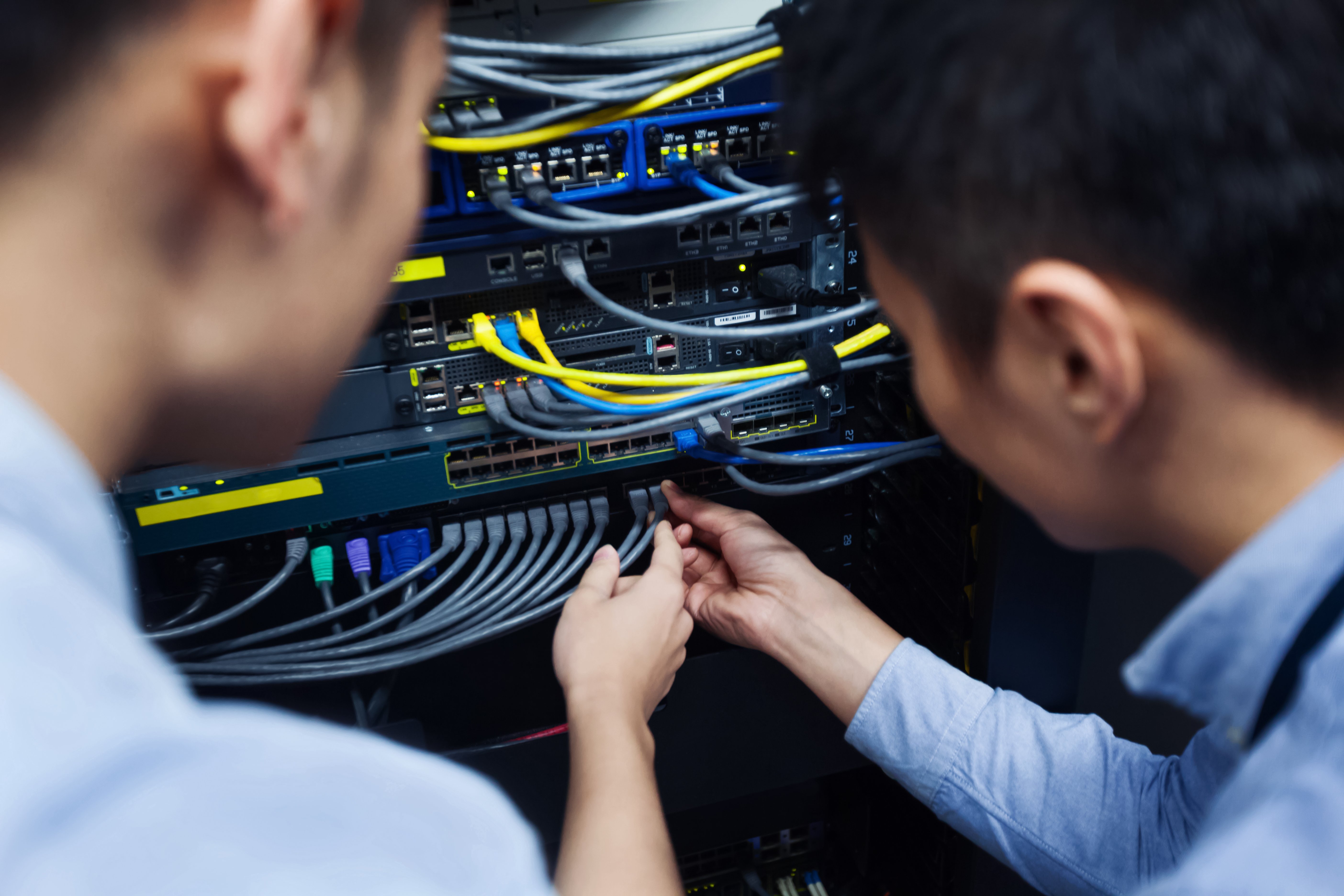 Two people inspecting network cables