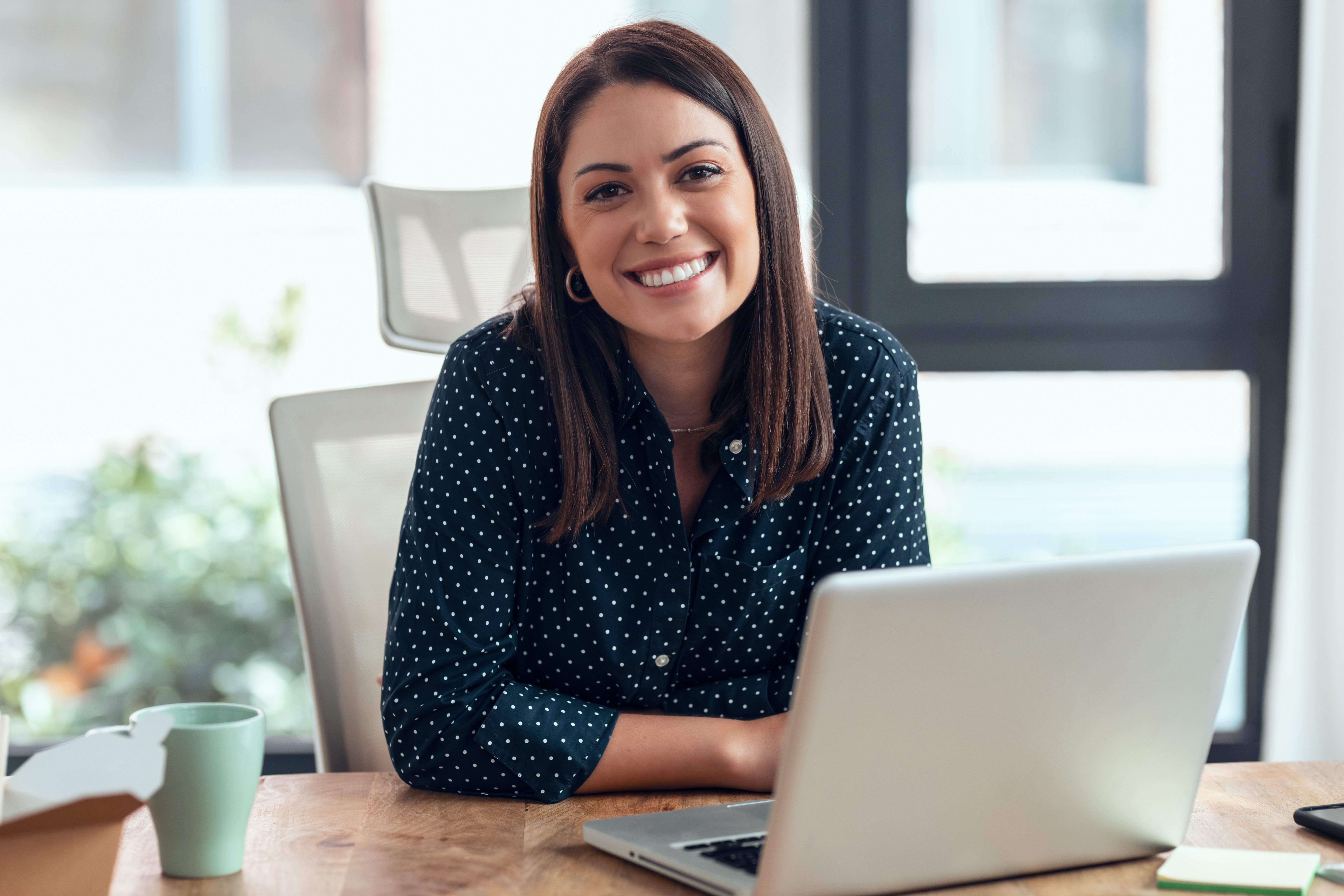 Smiling woman sitting in front of laptop