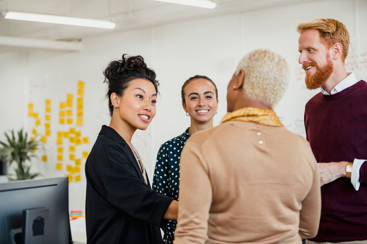 Office colleagues standing in a small group discussing something