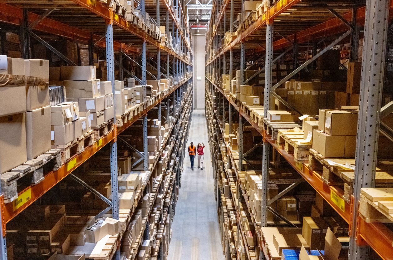 High-angle view of a warehouse manager walking with foreman checking stock