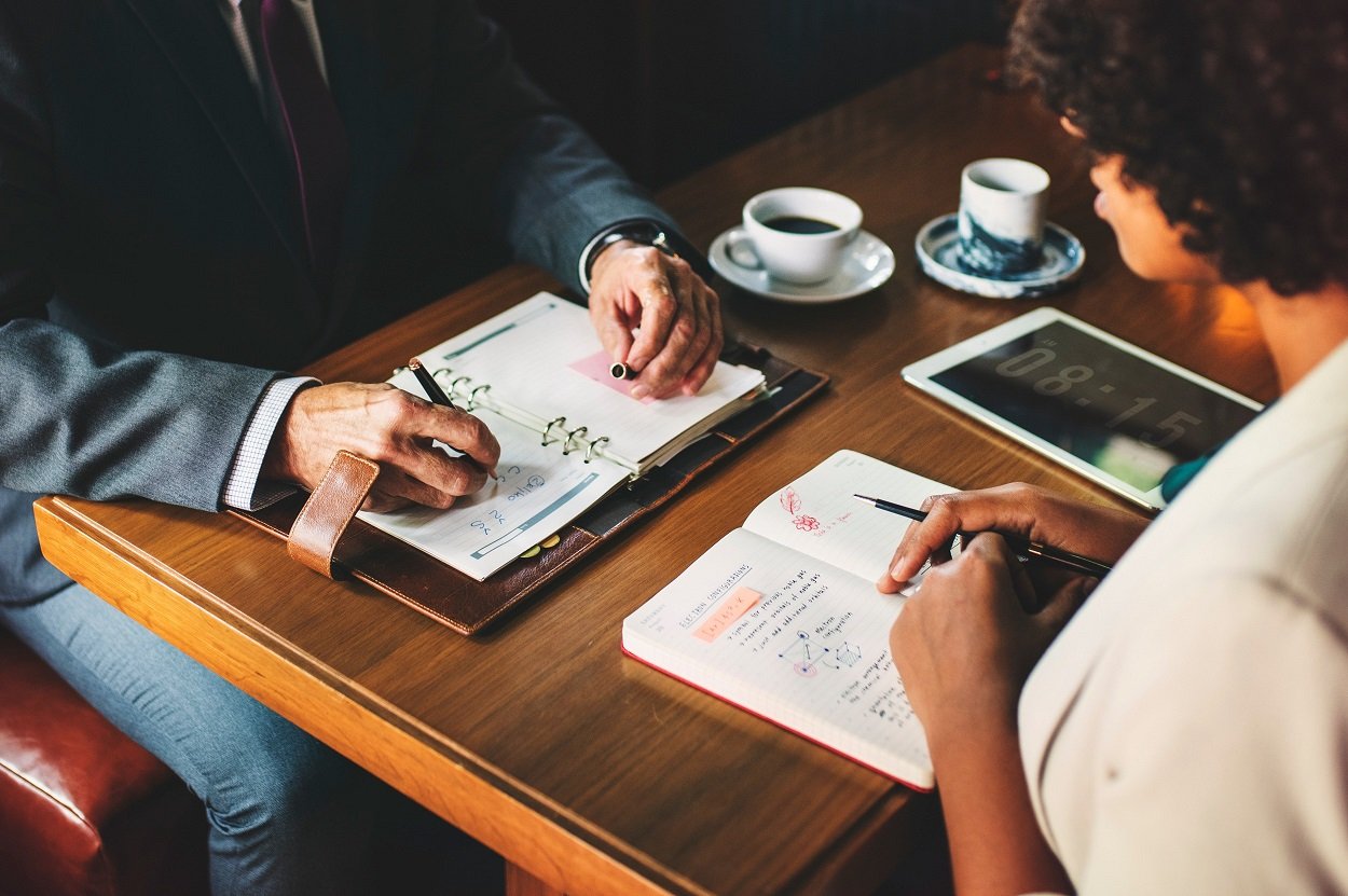 Lawyer and legal assistant sitting across from each other at a table