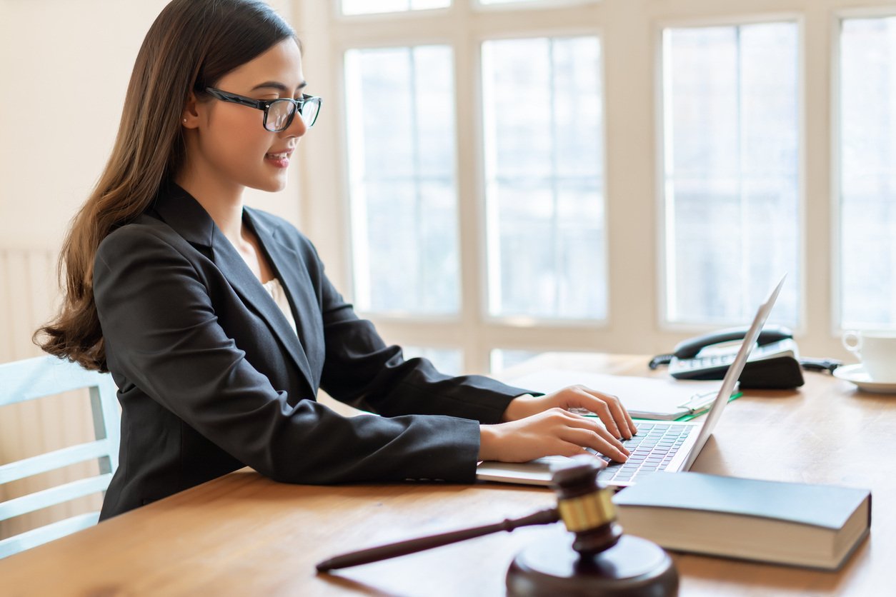 Legal assistant working with laptop in office