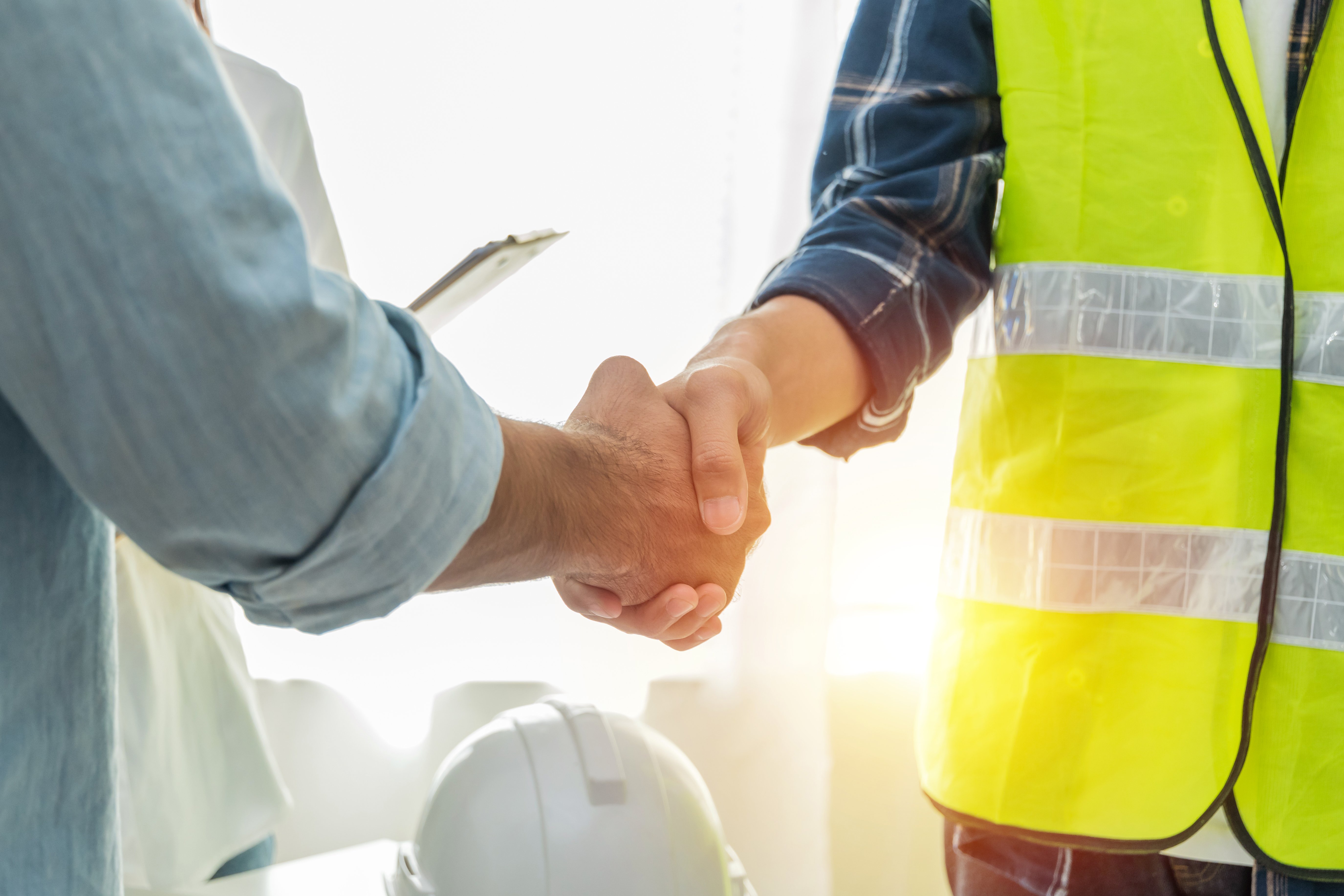 Construction manager and subcontractor shaking hands