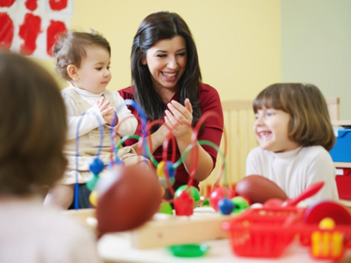 A preschool teacher with two young students