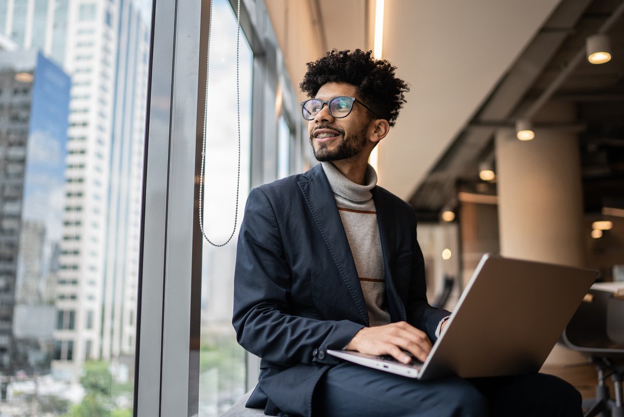 Man sitting in office looking out window