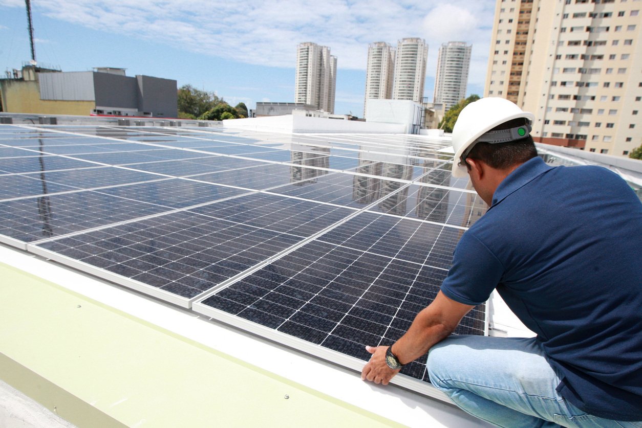 A worker installing solar panels on a roof