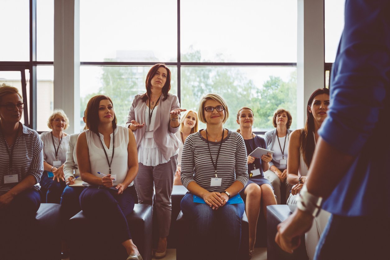 Businesswoman raising a question to the speaker during training