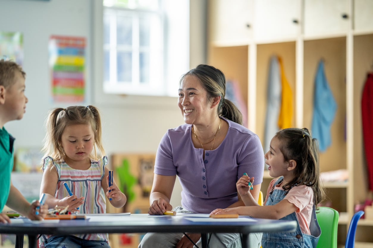 EA interacting with young children in a classroom