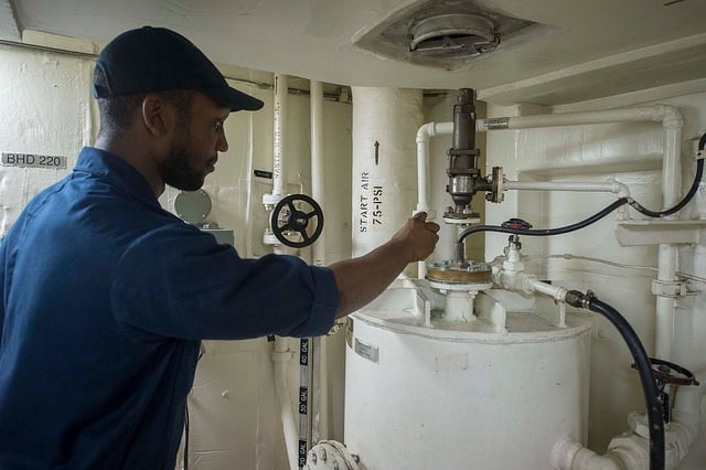 Gas technician with hand on pipe