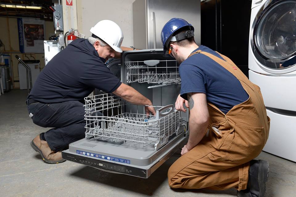Appliance repair instructor and student working on a dishwasher