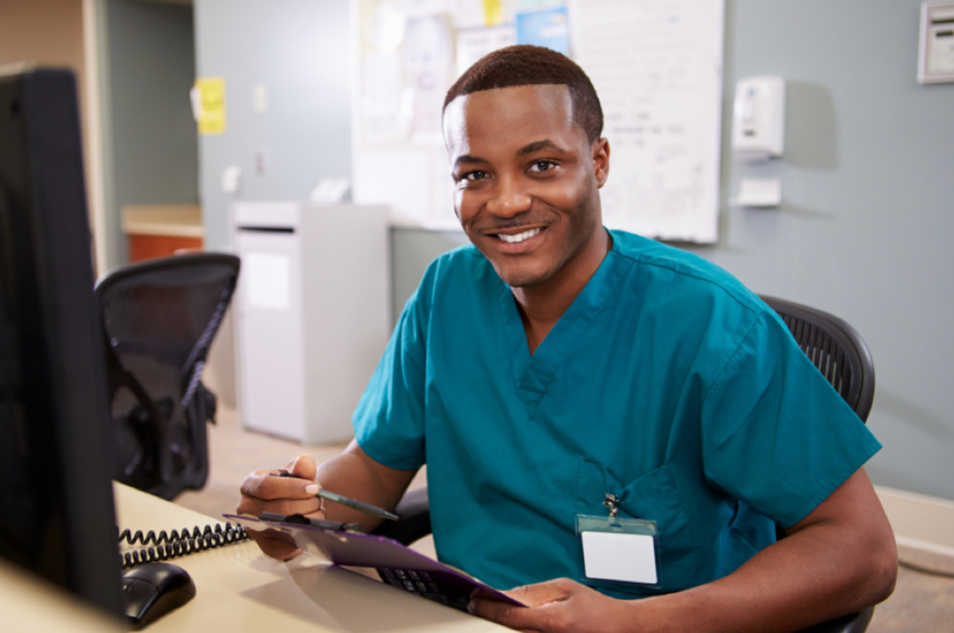 Medical office administrator smiling while sitting at desk