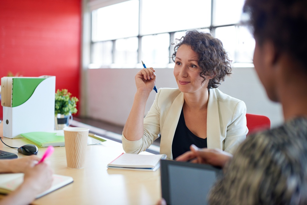Unposed group of creative business people in an open concept office brainstorming their next project.-5.jpeg
