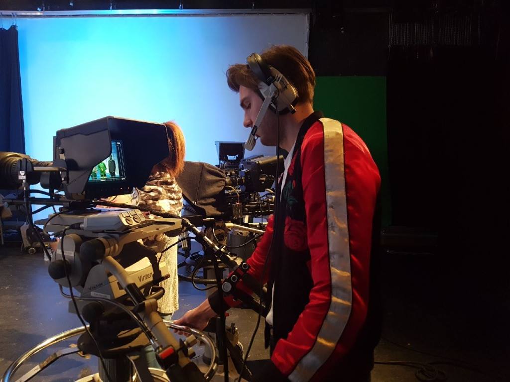 Side view of TV camera operator in studio
