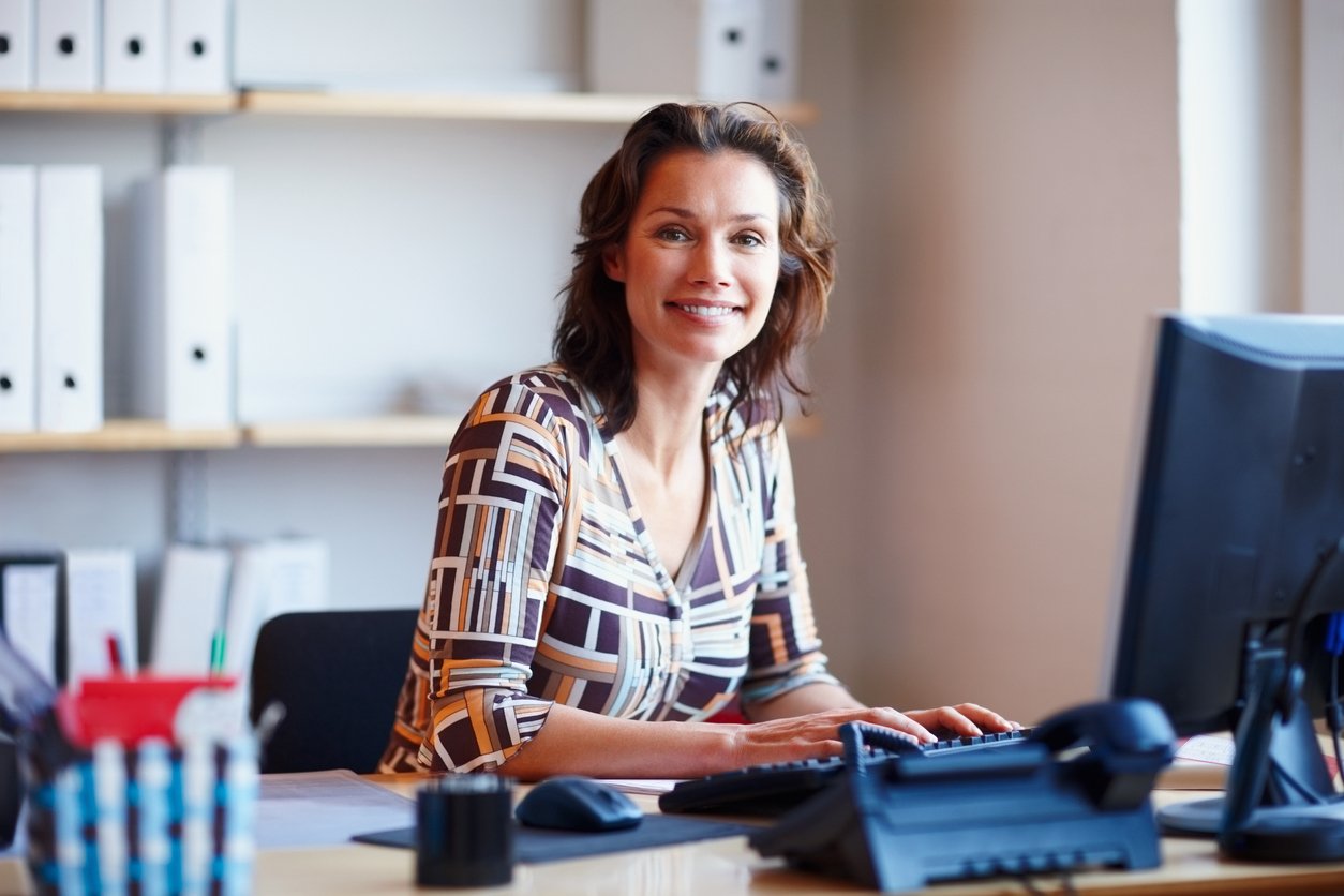 Smiling businesswoman at desk with computer
