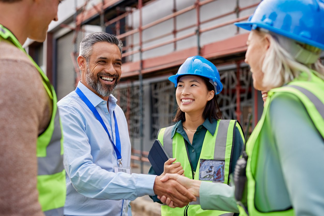 Construction manager shaking hands with tradesperson