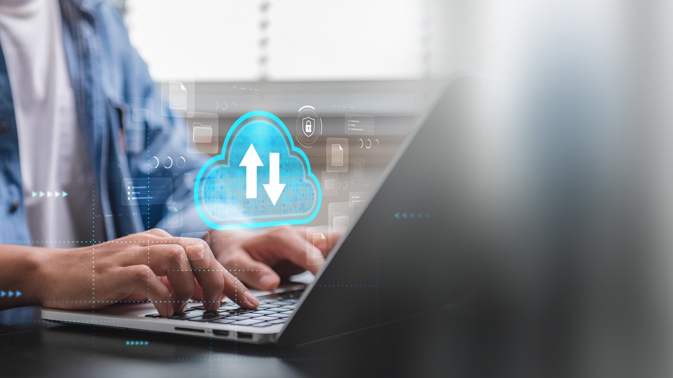 Person using laptop with cloud data upload and download icon