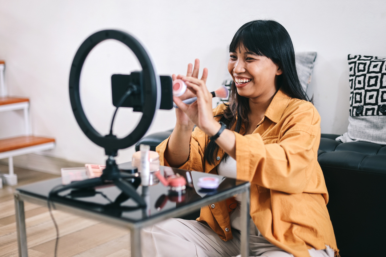 Young woman filming a vlog at home