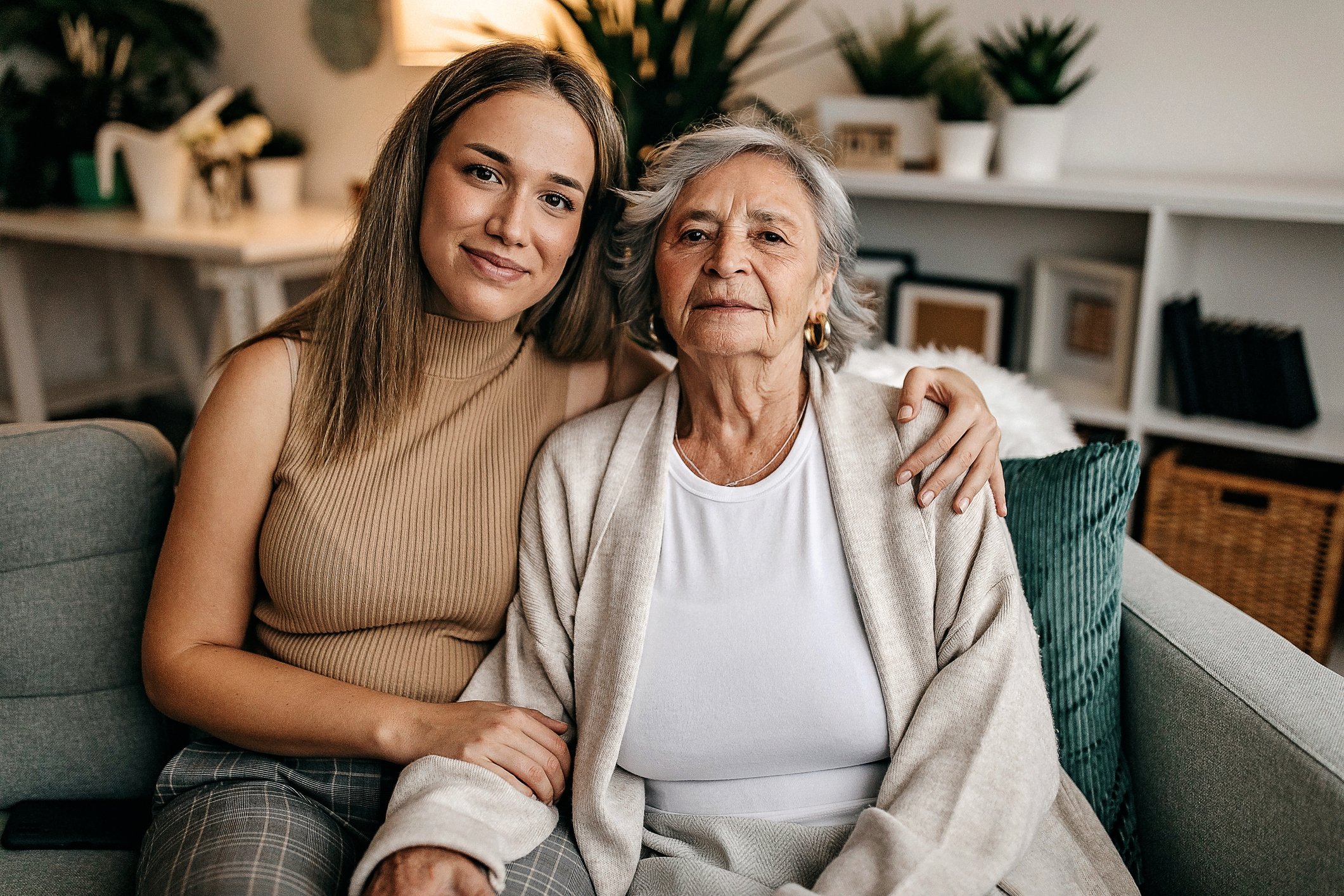 Senior woman and her granddaughter sitting on couch