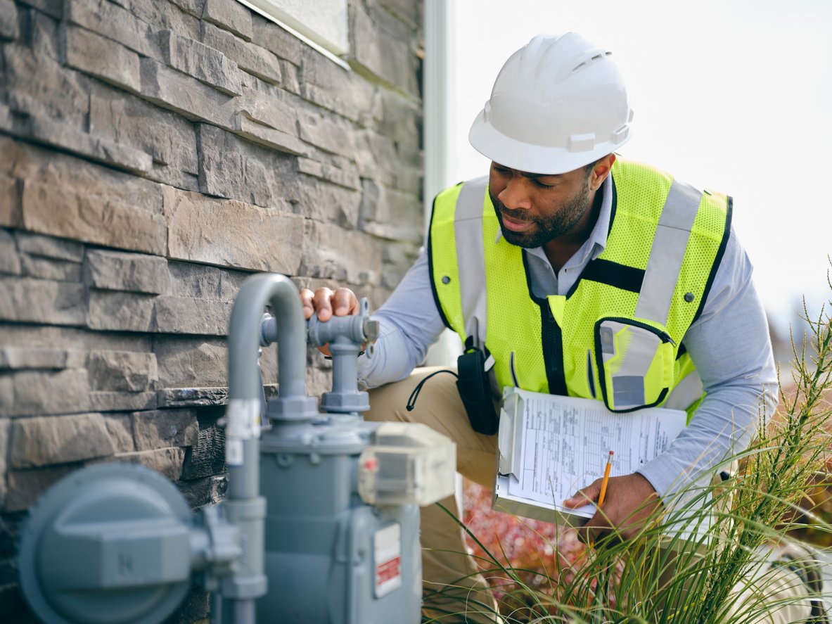 Gas fitter examining a home natural gas meter
