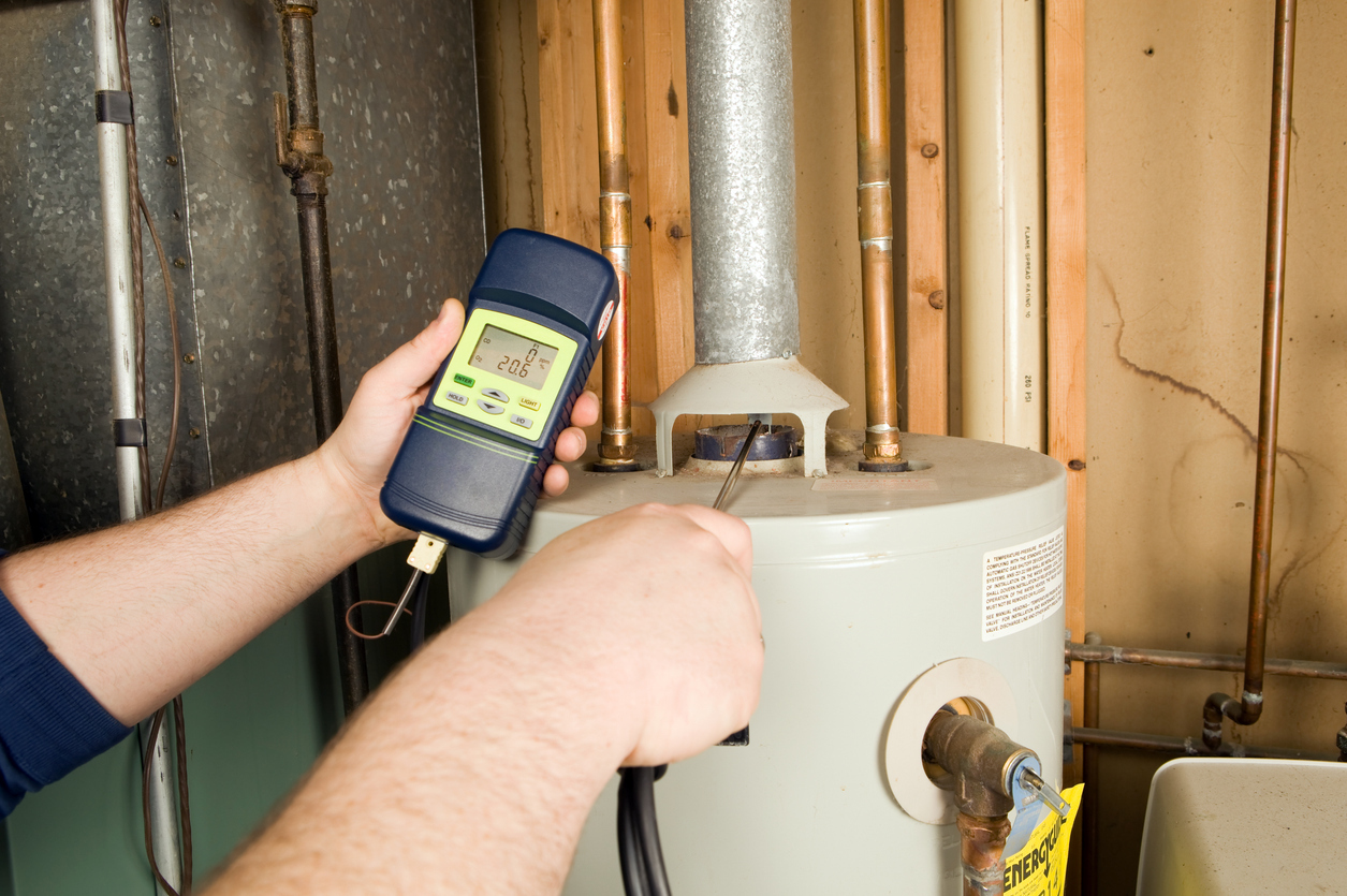 Technician checking carbon monoxide level on gas water heater exhaust