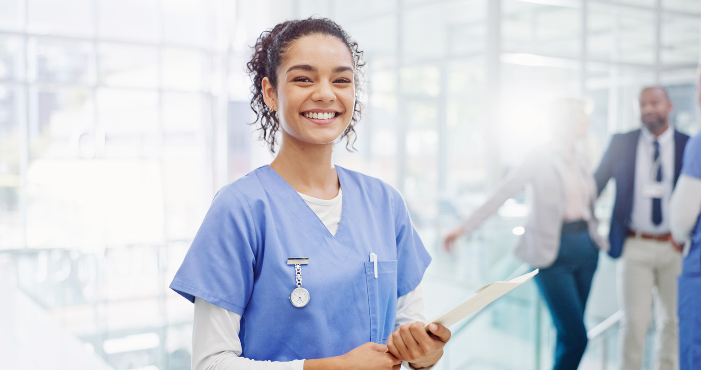 Smiling healthcare worker wearing scrubs and holding a medical report
