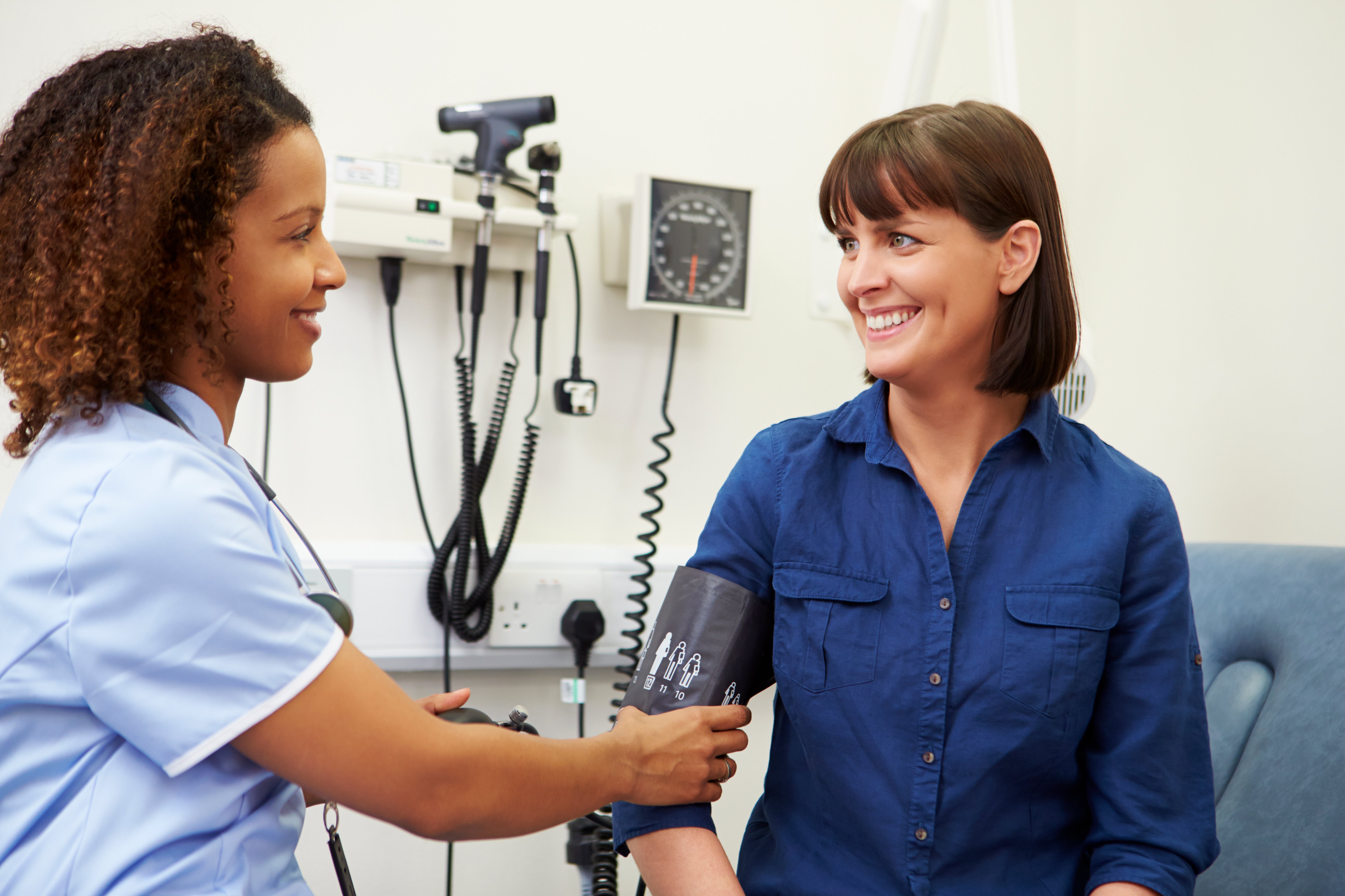 Medical office assistant taking patient blood pressure