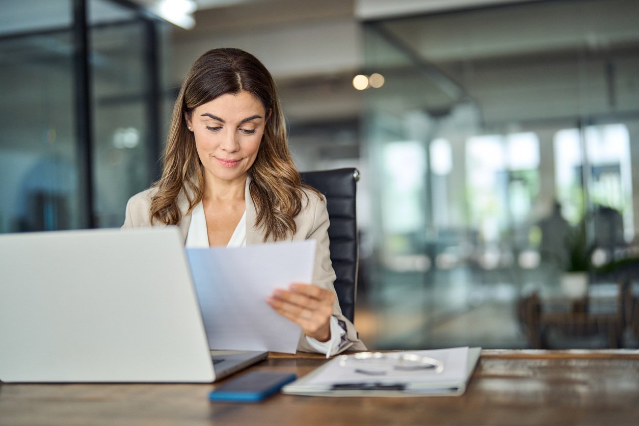 Legal professional holding paper sitting at desk in office