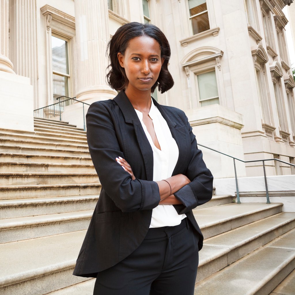 Legal assistant standing on the steps of a courthouse