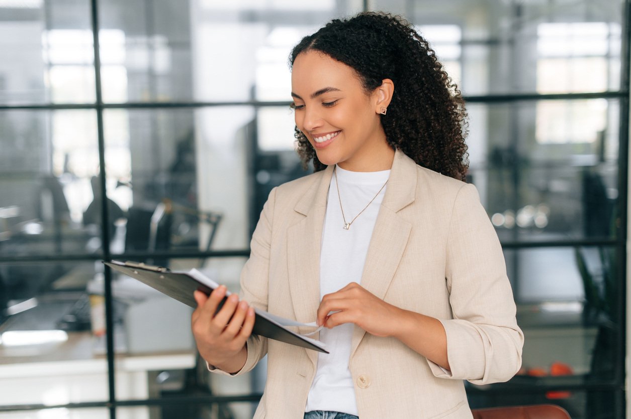 Project manager standing in a modern office looking at documents