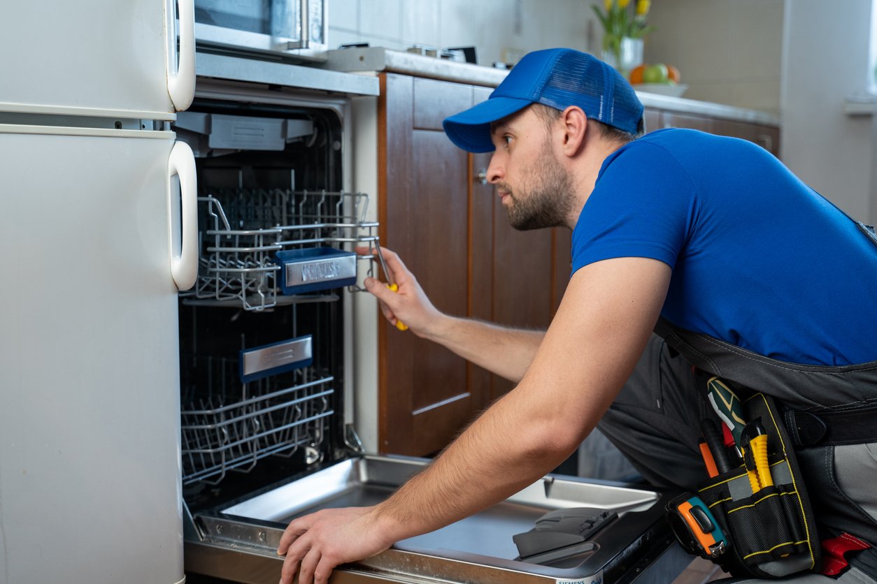 Technician repairing dishwasher